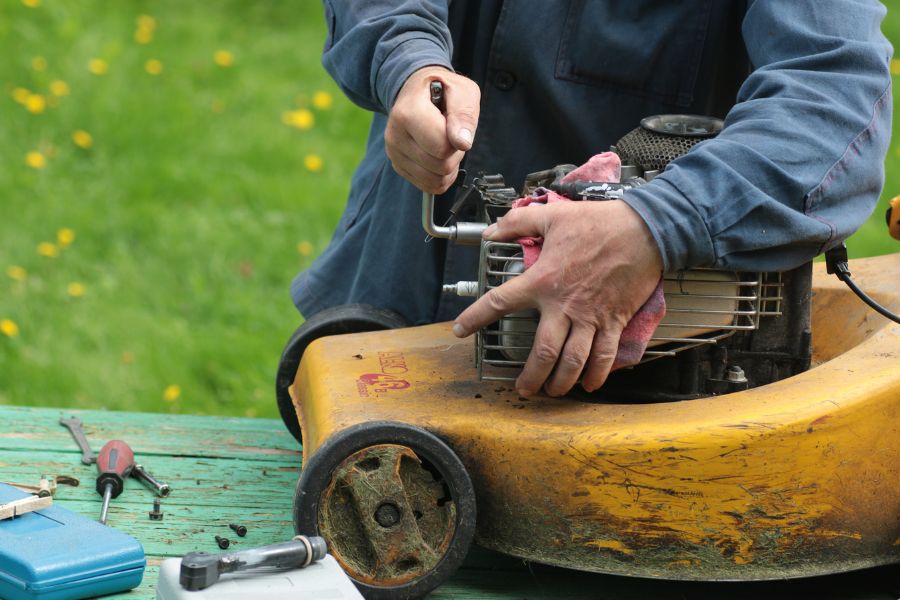 repair man working on lawn mower